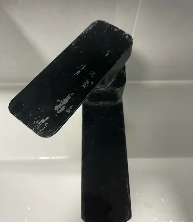 Black faucet with peeling paint