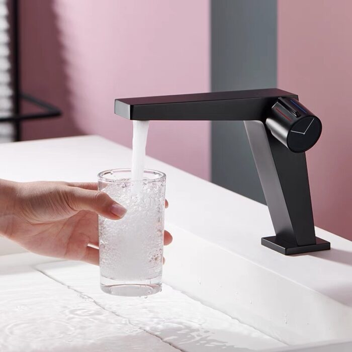 Sleek black kitchen faucet pouring water into glass, modern design, water flow control, optimal for stylish kitchen spaces.