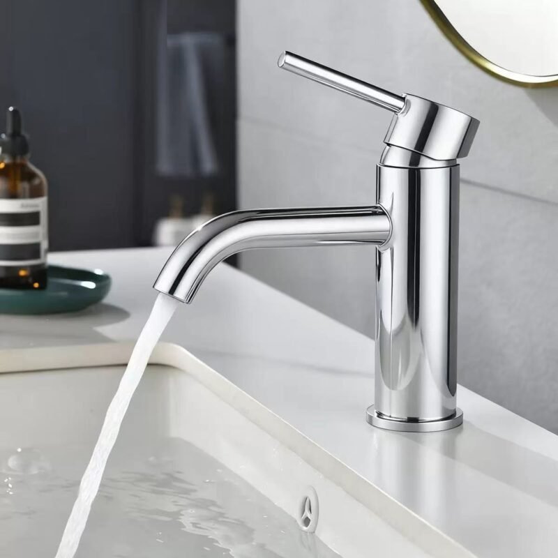 Sleek modern chrome kitchen faucet with water flow on a stylish countertop.