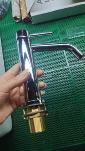 Shiny chrome kitchen faucet with gold threaded base, modern design, ideal for contemporary bathrooms or kitchens.