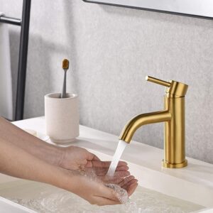 Shiny gold bathroom sink faucet with stream of water, modern and stylish design for luxury bathrooms.