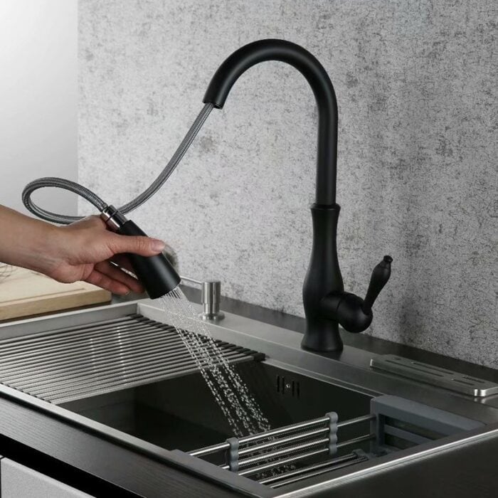 Modern black kitchen faucet with pull-out sprayer, stainless steel sink, and sleek design.