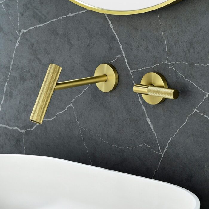 Brass wall-mounted faucet and handle for modern bathroom decor.