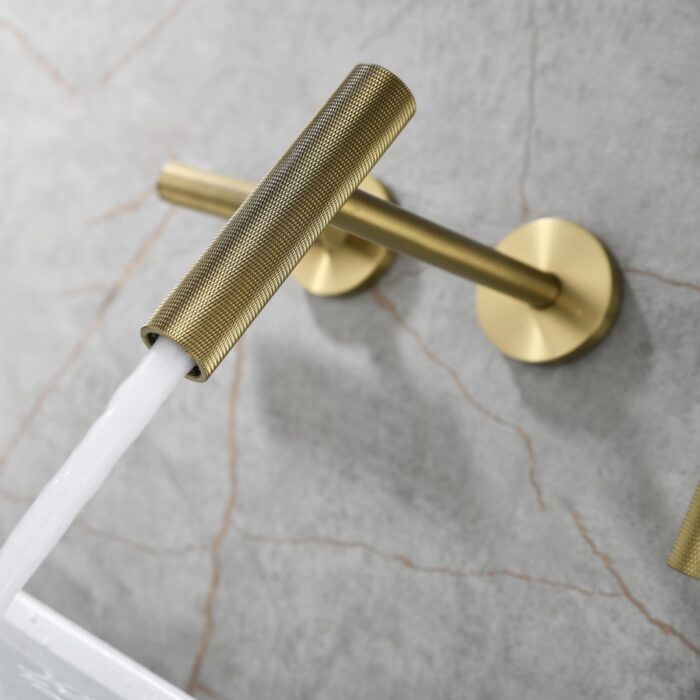 Shiny gold wall-mounted faucet with water flowing, modern bathroom sink fixture.