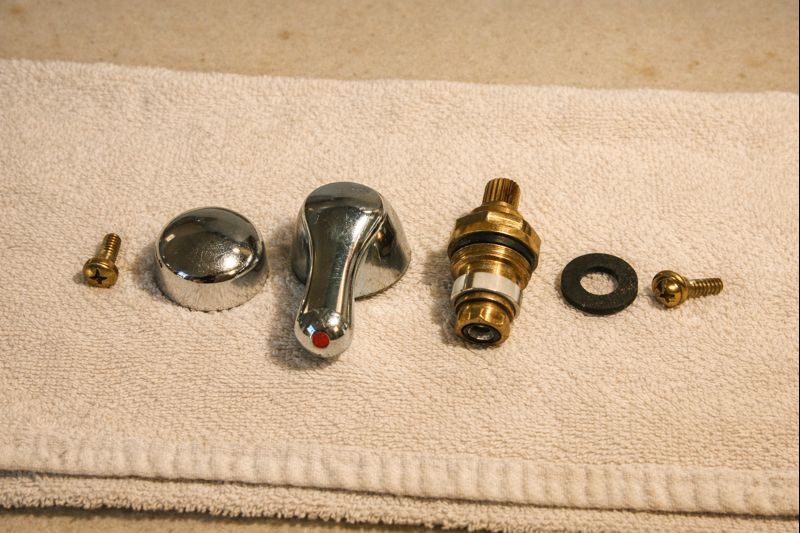 Headworks and faucet parts laid out in order on a towel