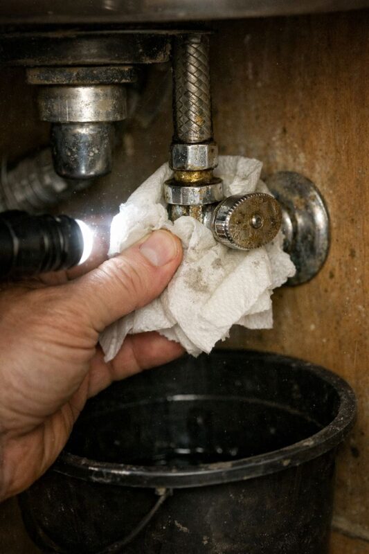 Paper towel leak test under the sink after tightening a faucet