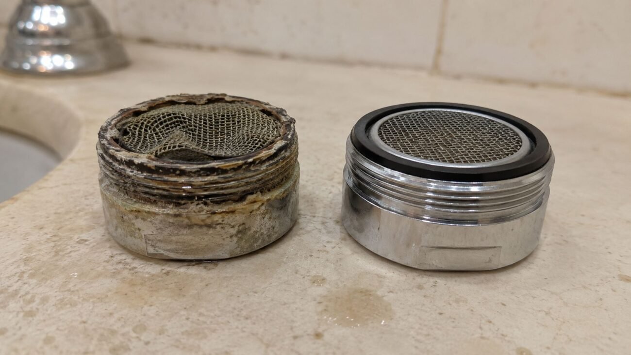 Old damaged faucet aerator compared with a new replacement aerator